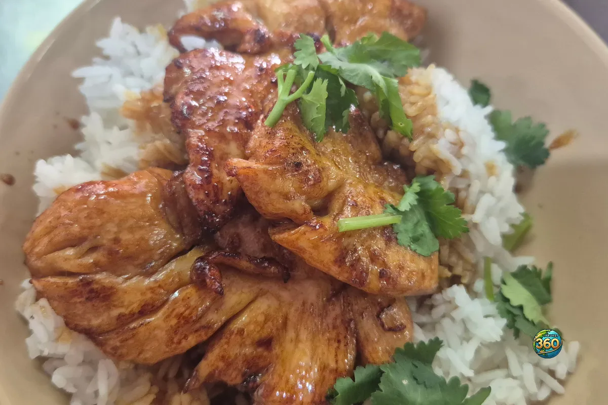 Bol de khao gai yang avec riz blanc, morceaux de poulet grillé thaï et coriandre fraîche