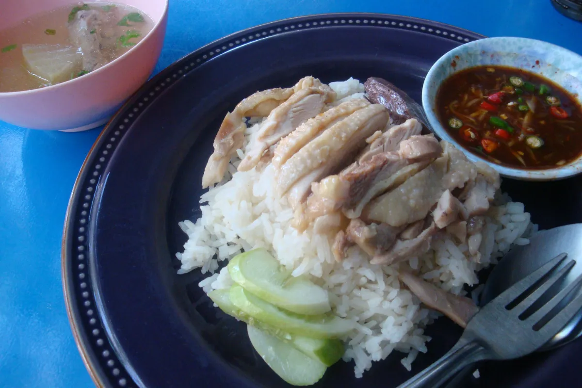 Assiette de khao man gai avec riz au poulet thaï, concombre, sauce pimentée et bouillon