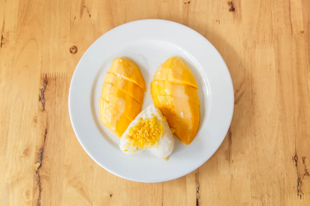Assiette de khao niao mamuang avec mangue fraîche, riz gluant, lait de coco et haricots mungo