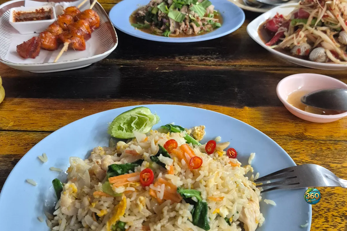 Assiette de khao pad avec riz sauté thaï, œuf, légumes, piments rouges et plats thaïlandais en arrière-plan
