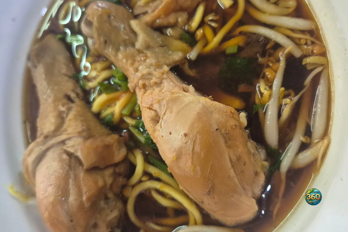 Bol de kuay teow gai toon avec nouilles jaunes, pilons de poulet braisé, bouillon foncé et pousses de soja
