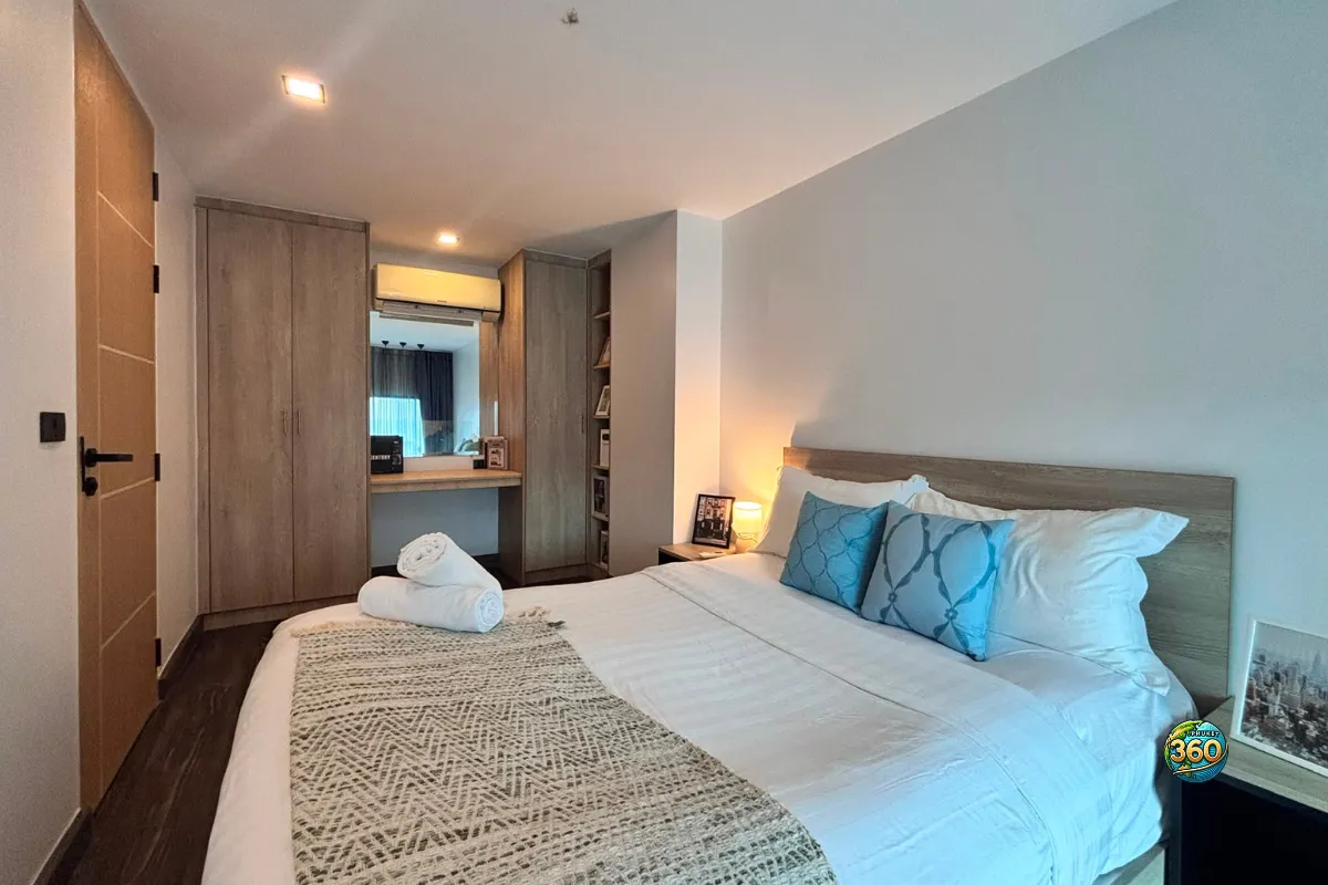 Chambre du duplex à Utopia Nai Harn, Phuket, avec lit double, rangements, coiffeuse, miroir, climatisation et décoration moderne
