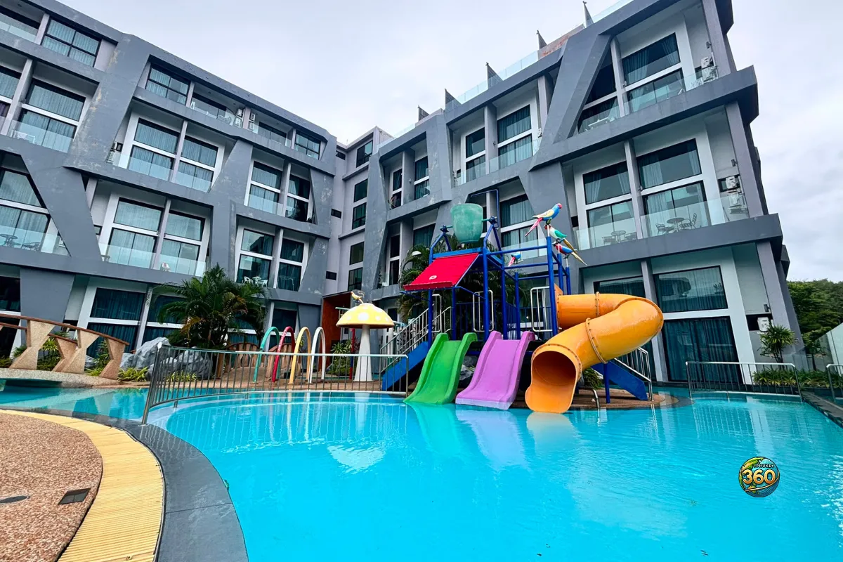 Piscine de la résidence Utopia Nai Harn à Phuket avec toboggans colorés, jeux aquatiques et bâtiments autour