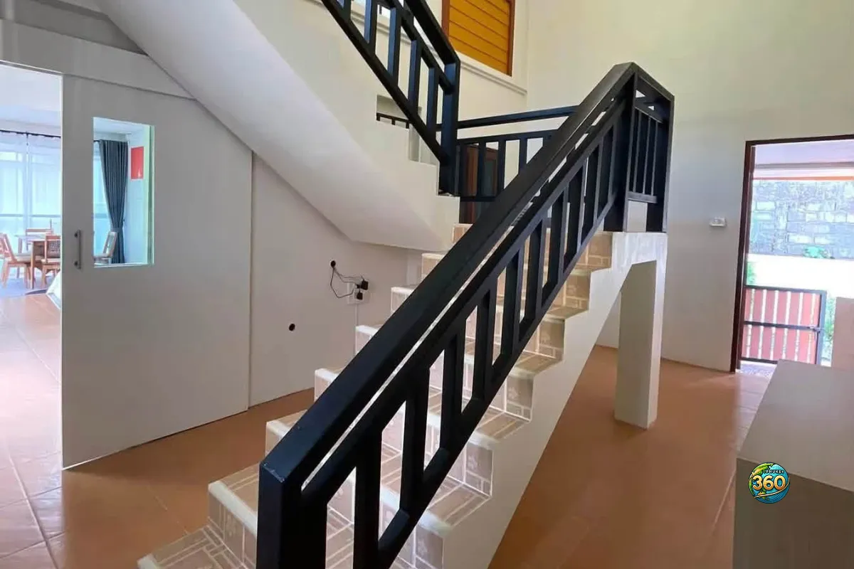 Escalier intérieur de la maison 3 chambres à louer à Bang Tao, Phuket, avec rampe noire et accès aux pièces de l’étage
