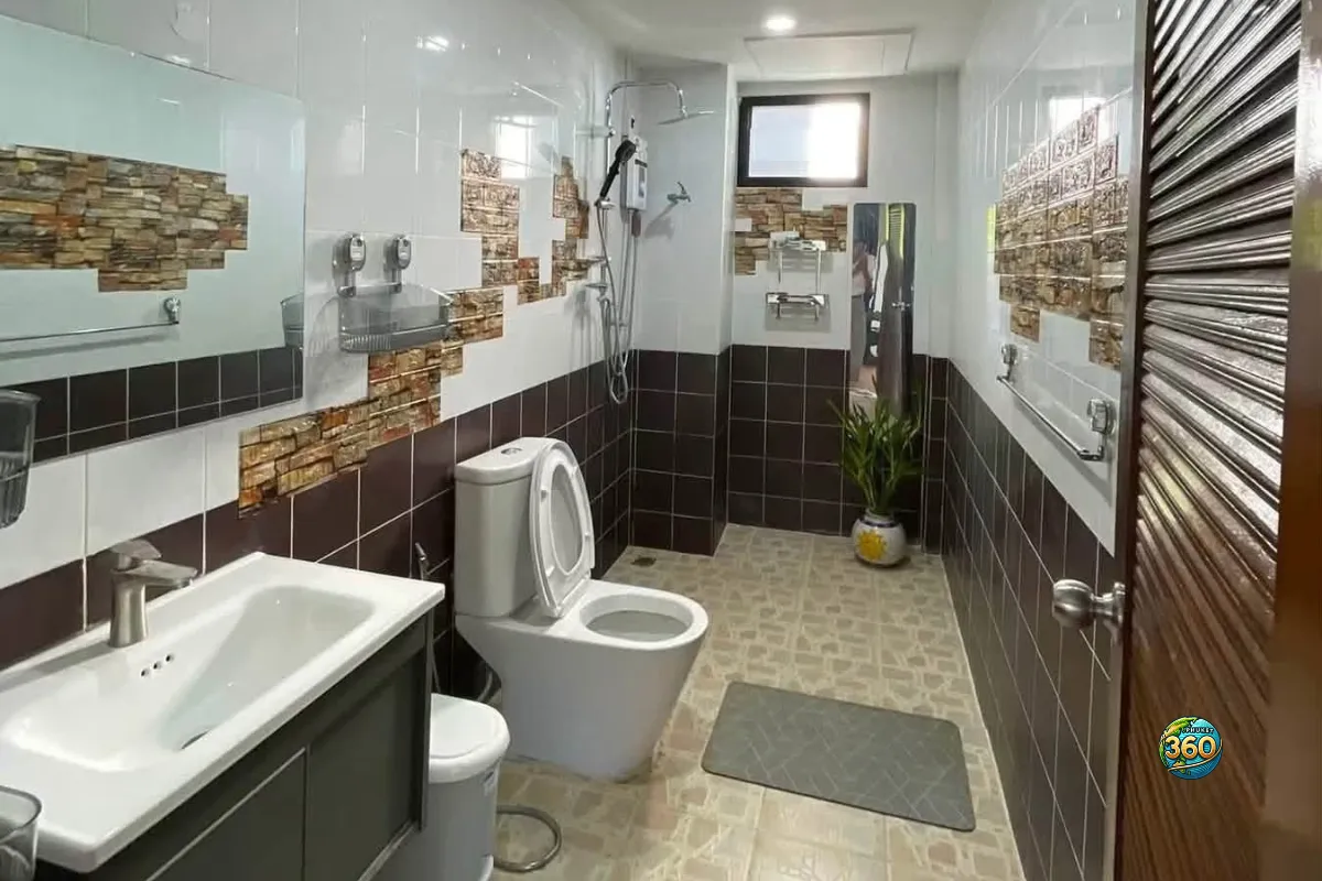 Salle de bain de la maison 3 chambres à louer à Bang Tao, Phuket, avec douche, toilettes, lavabo, miroir et carrelage mural décoratif
