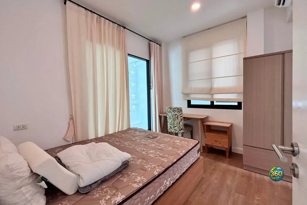 Chambre meublée de la maison Mono Plus Palai à Phuket avec lit, bureau, chaise, armoire, rideaux et climatisation
