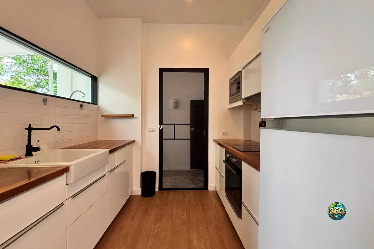 Cuisine équipée de la maison Mono Plus Palai à Phuket avec évier, réfrigérateur, four, plaque de cuisson, micro-ondes et plan de travail en bois