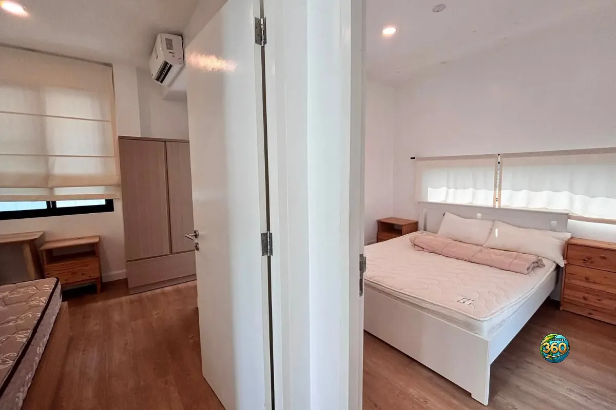 Vue sur deux chambres de la maison Mono Plus Palai à Phuket avec lits, tables de chevet, rangements et sols imitation bois