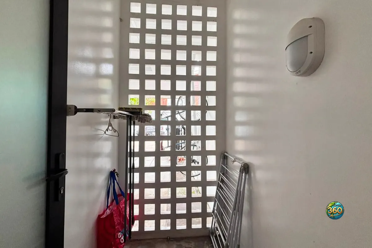 Espace de rangement de la maison Mono Plus Palai à Phuket avec mur ajouré, étendoir pliable et porte vitrée