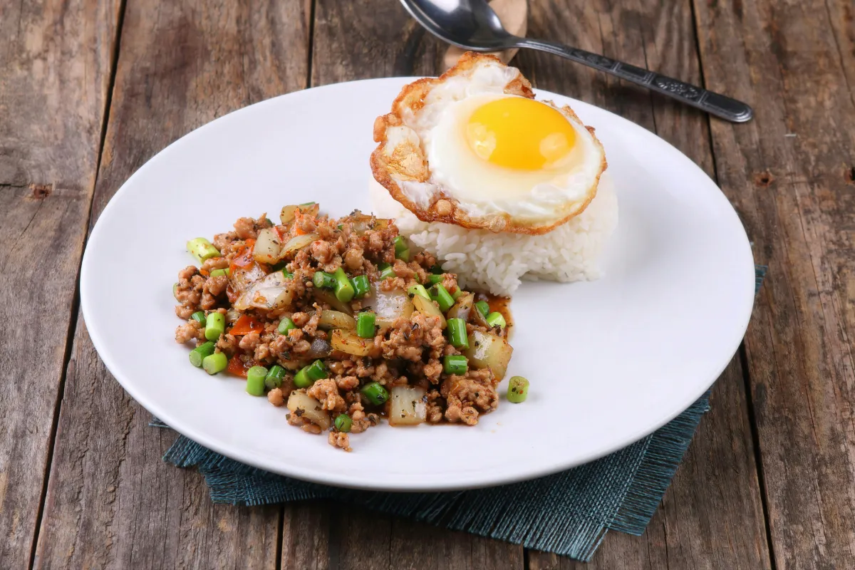 Assiette de pad kra pao kai dao avec riz blanc, viande hachée sautée aux herbes et œuf frit