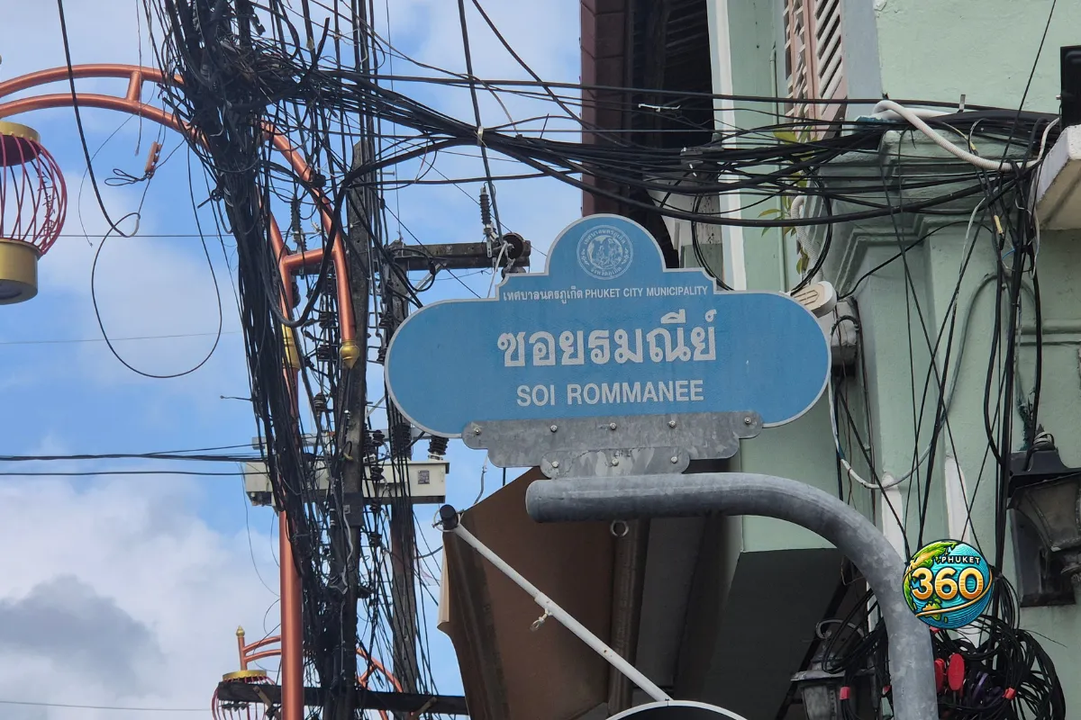 Panneau de Soi Rommanee à Phuket Old Town, entouré de câbles électriques et de façades anciennes