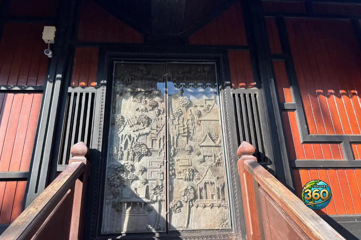 Grande porte en bois sculptée représentant des scènes traditionnelles dans le temple Wat Chalong à Phuket
