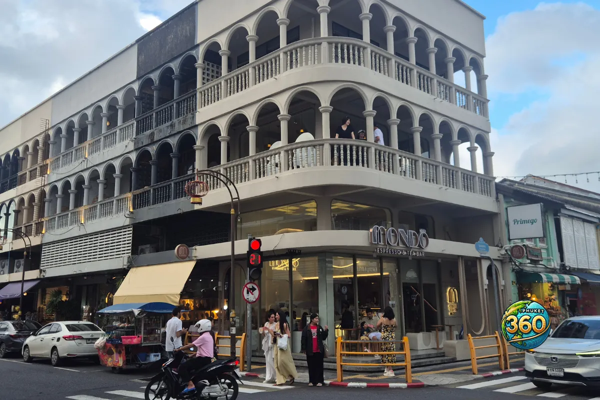 Rue animée de Phuket Old Town avec façades colorées, scooters et guirlandes lumineuses