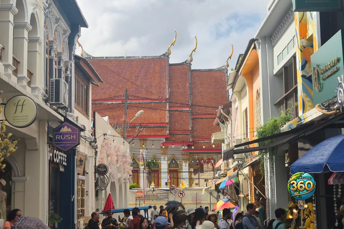 Rue animée de Phuket Old Town avec boutiques, touristes et temple thaïlandais en arrière-plan