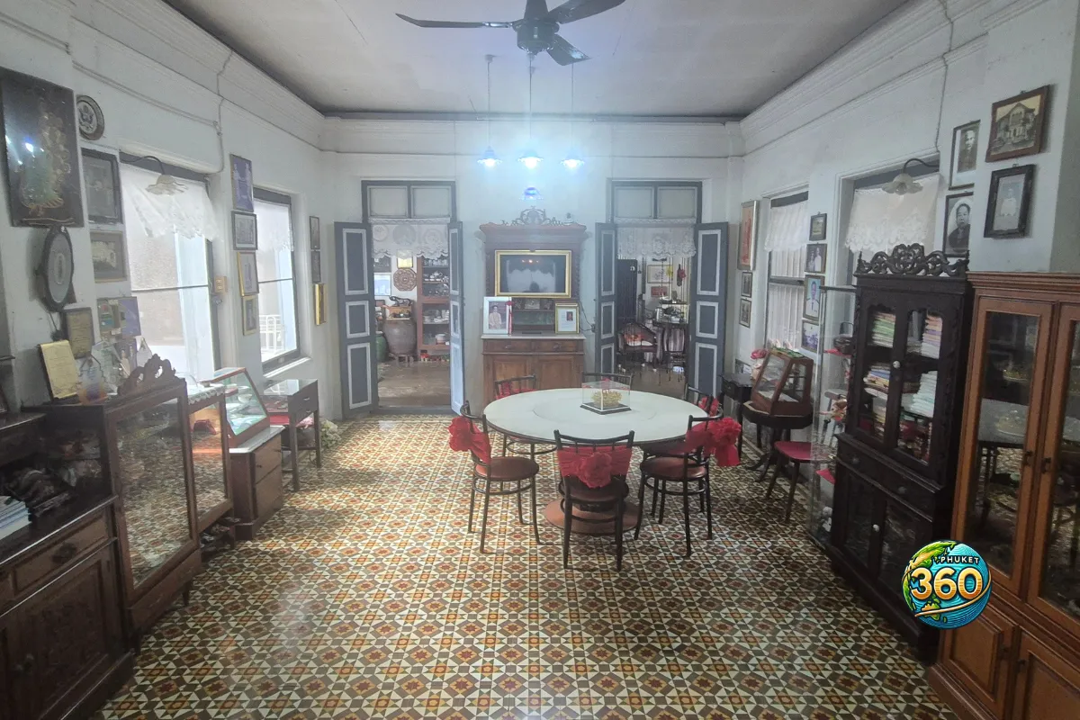 Salon ancien de Chinpracha House avec table ronde, meubles en bois et sol à motifs
