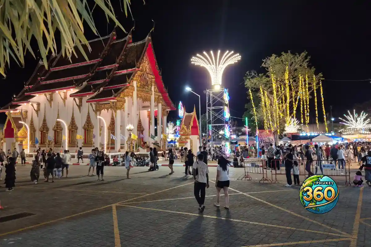 Vue large du temple Wat Chalong illuminé avec visiteurs pendant la foire annuelle à Phuket