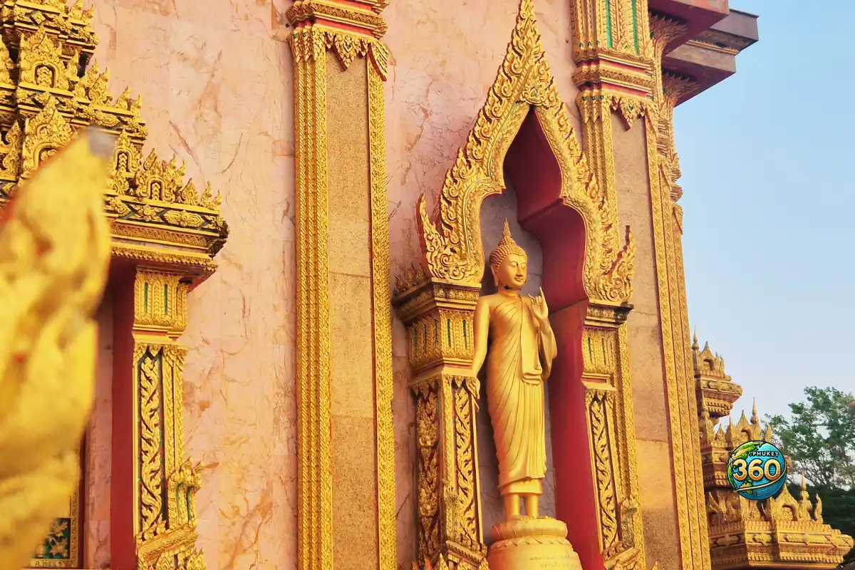 Statue de Bouddha dans une niche dorée sur la façade du Wat Chalong à Phuket