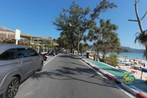 Route longeant Kata Beach avec places de parking pour voitures et scooters face à la plage